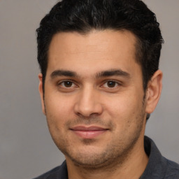 Joyful white young-adult male with short  black hair and brown eyes