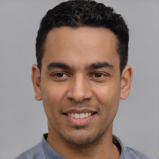 Joyful latino young-adult male with short  black hair and brown eyes