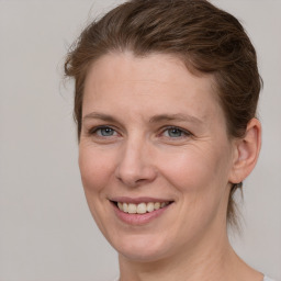 Joyful white adult female with medium  brown hair and grey eyes