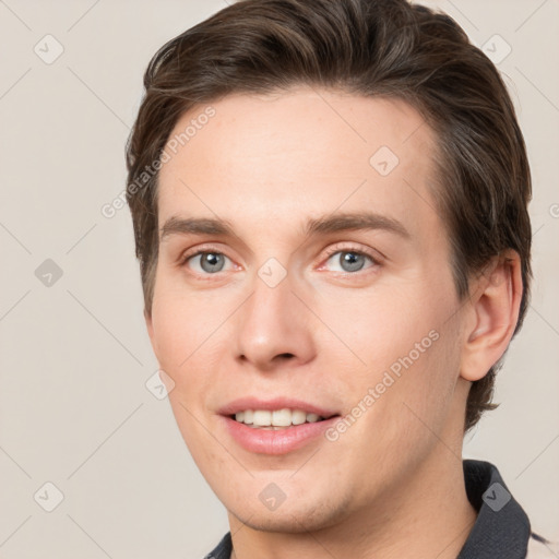 Joyful white young-adult male with short  brown hair and grey eyes