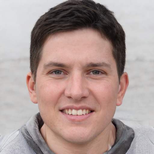 Joyful white adult male with short  brown hair and grey eyes