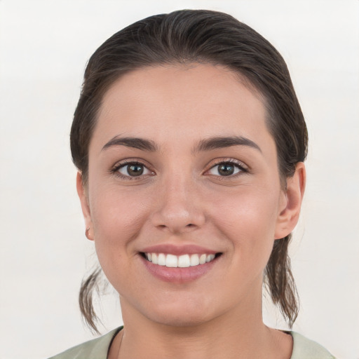 Joyful white young-adult female with medium  brown hair and grey eyes