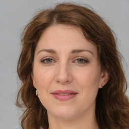 Joyful white young-adult female with long  brown hair and green eyes