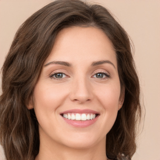 Joyful white young-adult female with medium  brown hair and green eyes