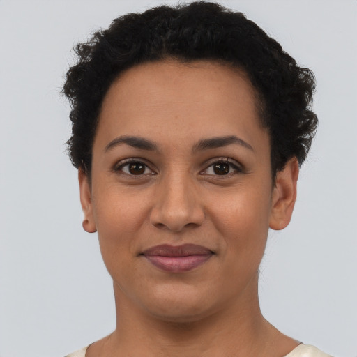Joyful latino young-adult female with short  black hair and brown eyes