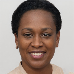 Joyful black young-adult female with short  black hair and brown eyes
