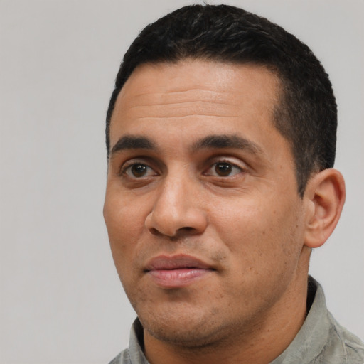 Joyful latino adult male with short  black hair and brown eyes