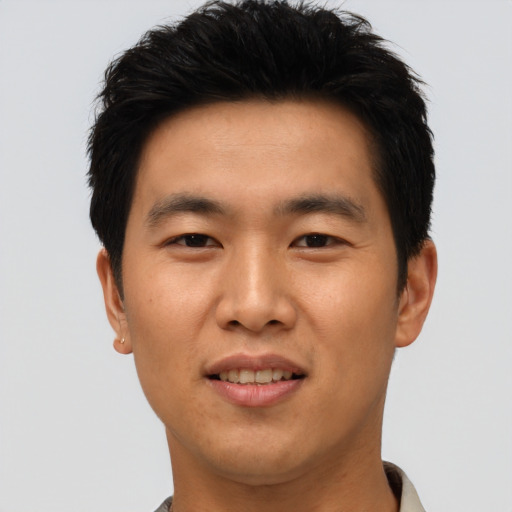 Joyful asian young-adult male with short  black hair and brown eyes