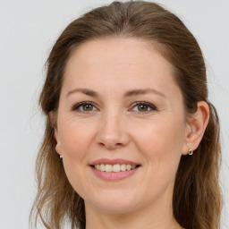 Joyful white young-adult female with long  brown hair and grey eyes