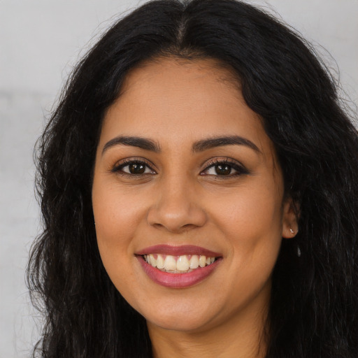 Joyful latino young-adult female with long  brown hair and brown eyes