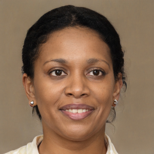 Joyful black adult female with medium  brown hair and brown eyes