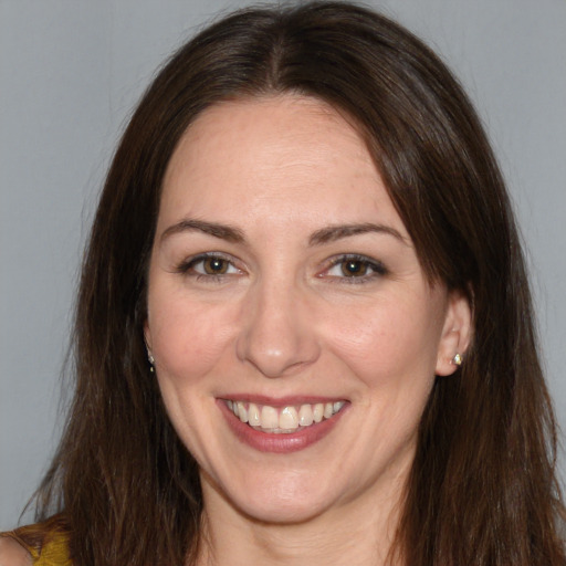 Joyful white adult female with long  brown hair and brown eyes