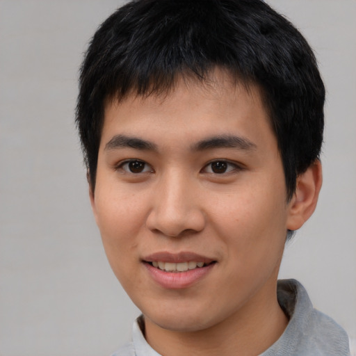 Joyful asian young-adult male with short  black hair and brown eyes