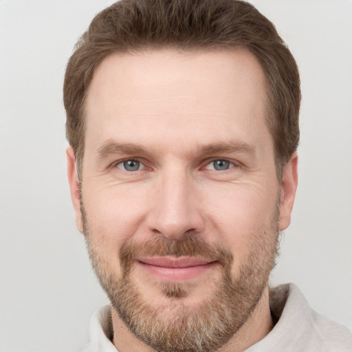 Joyful white adult male with short  brown hair and grey eyes