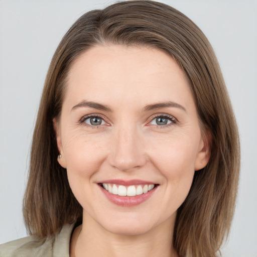 Joyful white young-adult female with medium  brown hair and grey eyes