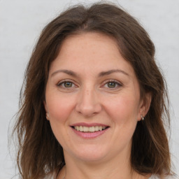 Joyful white adult female with long  brown hair and grey eyes