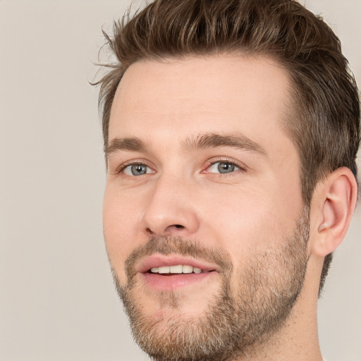 Joyful white young-adult male with short  brown hair and grey eyes