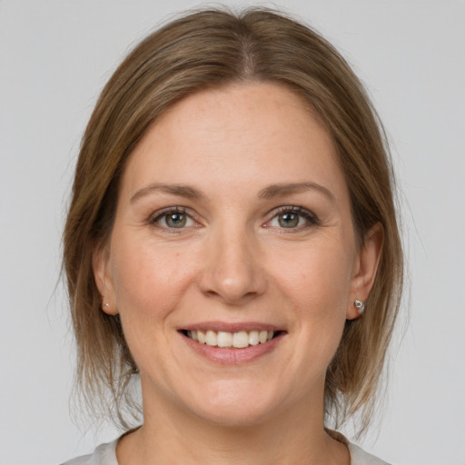 Joyful white young-adult female with medium  brown hair and grey eyes