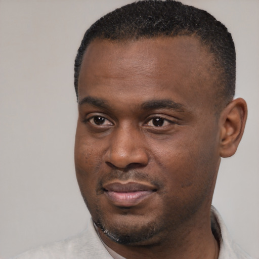 Joyful black young-adult male with short  black hair and brown eyes