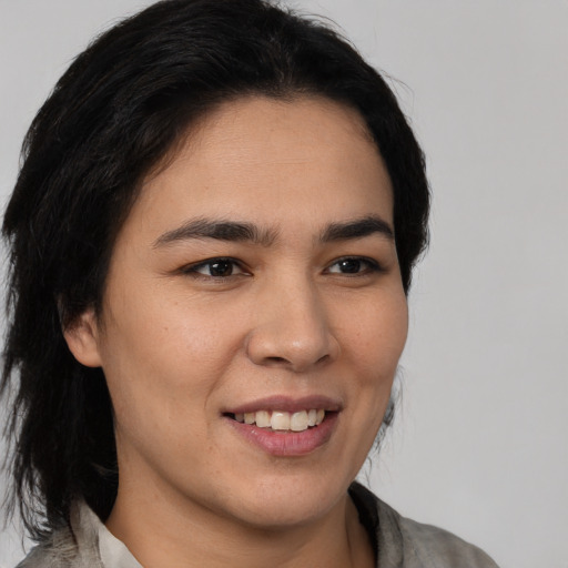 Joyful latino young-adult female with medium  brown hair and brown eyes