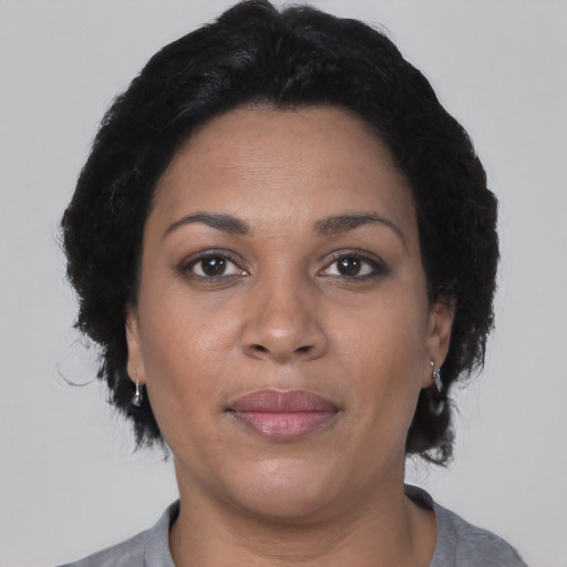 Joyful latino adult female with short  black hair and brown eyes