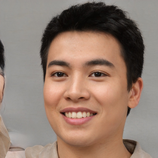 Joyful asian young-adult male with short  brown hair and brown eyes