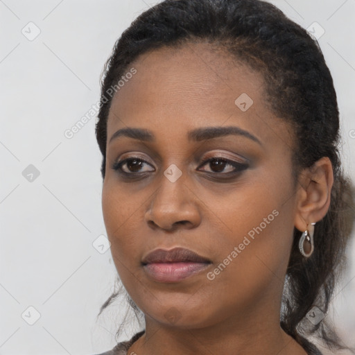 Joyful black young-adult female with long  black hair and brown eyes