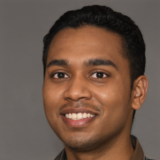 Joyful black young-adult male with short  black hair and brown eyes