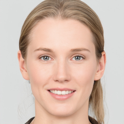 Joyful white young-adult female with long  brown hair and blue eyes