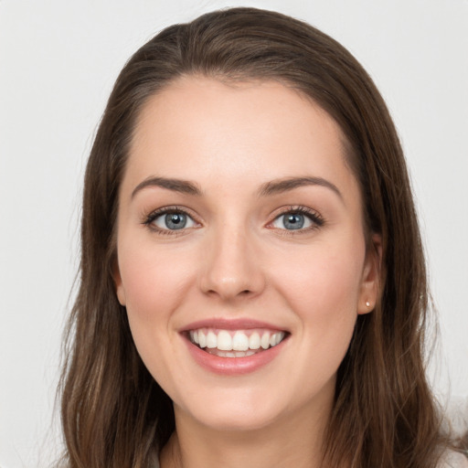 Joyful white young-adult female with long  brown hair and grey eyes