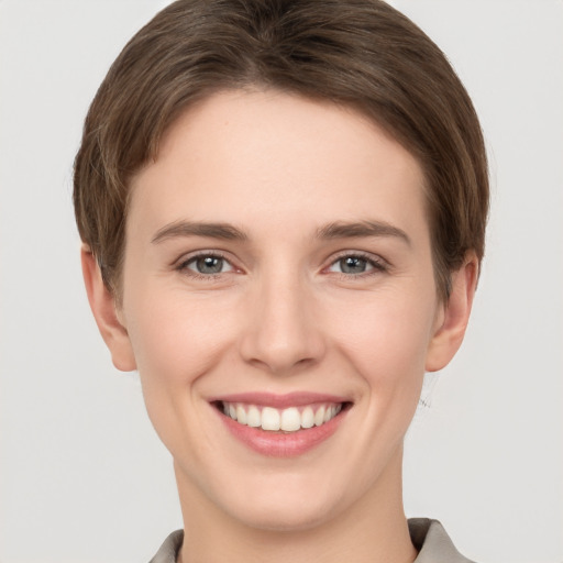 Joyful white young-adult female with short  brown hair and grey eyes