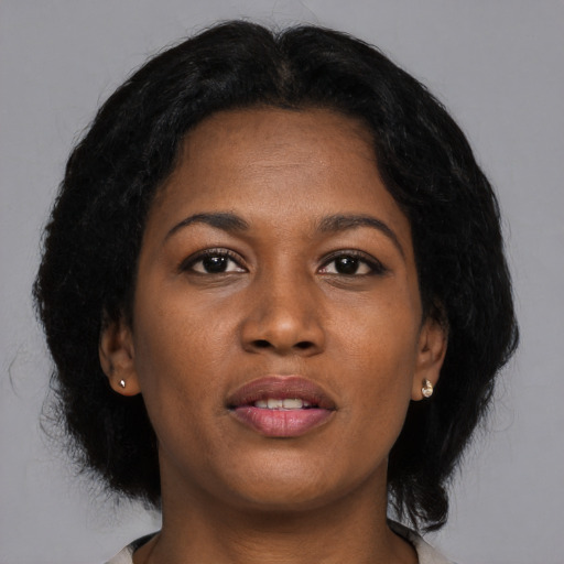 Joyful black young-adult female with medium  brown hair and brown eyes