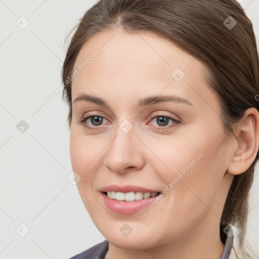 Joyful white young-adult female with medium  brown hair and grey eyes