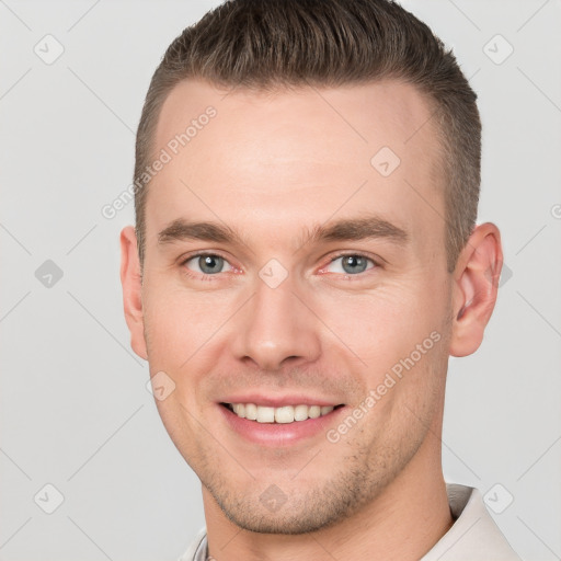 Joyful white young-adult male with short  brown hair and grey eyes