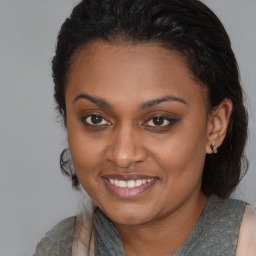 Joyful black young-adult female with long  brown hair and brown eyes