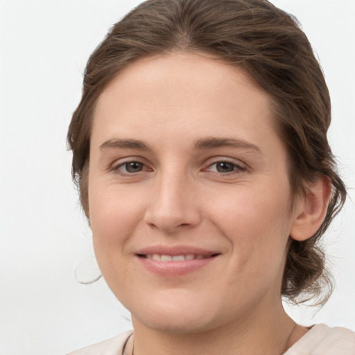 Joyful white young-adult female with medium  brown hair and grey eyes