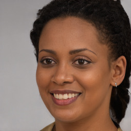 Joyful black young-adult female with long  brown hair and brown eyes