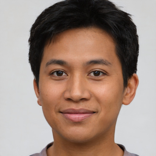 Joyful asian young-adult male with short  black hair and brown eyes