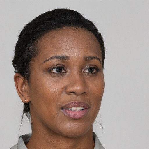 Joyful black young-adult female with short  brown hair and brown eyes