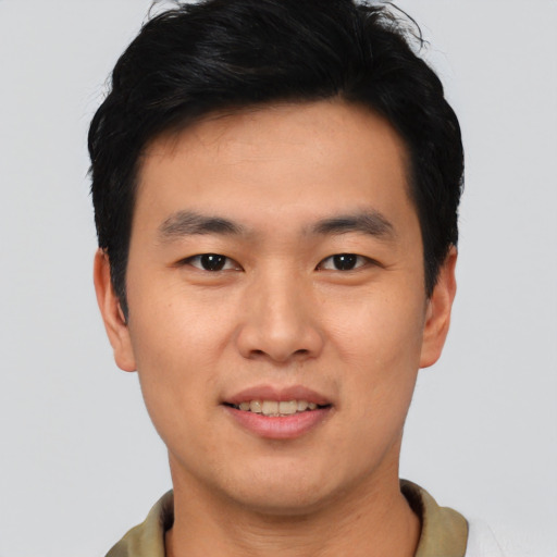 Joyful asian young-adult male with short  black hair and brown eyes