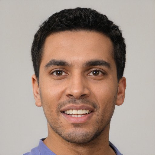 Joyful latino young-adult male with short  black hair and brown eyes