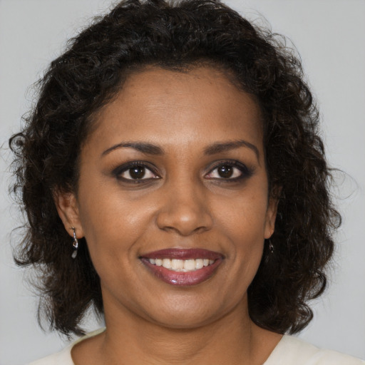 Joyful black young-adult female with medium  brown hair and brown eyes
