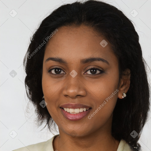 Joyful black young-adult female with long  black hair and brown eyes