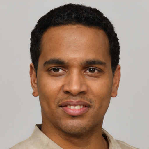 Joyful black young-adult male with short  black hair and brown eyes