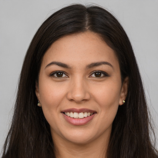 Joyful latino young-adult female with long  brown hair and brown eyes