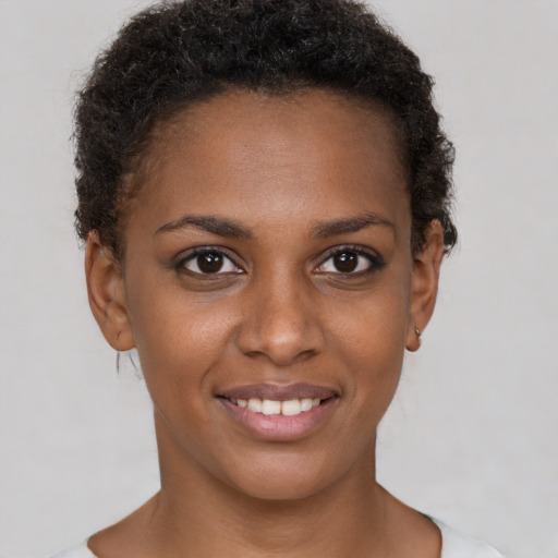 Joyful black young-adult female with short  brown hair and brown eyes