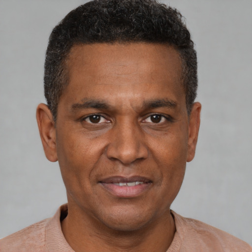 Joyful black adult male with short  brown hair and brown eyes