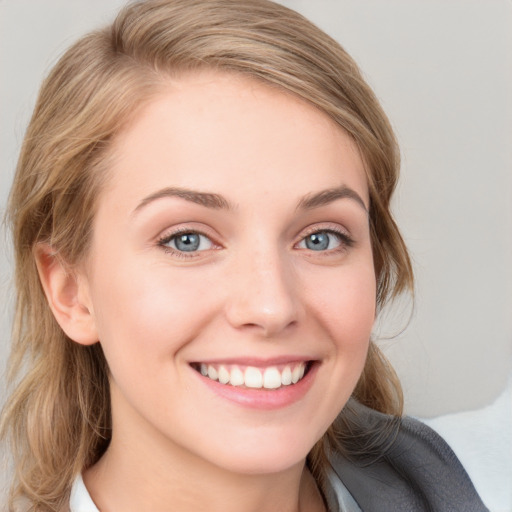 Joyful white young-adult female with medium  brown hair and blue eyes