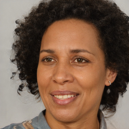 Joyful black adult female with medium  brown hair and brown eyes