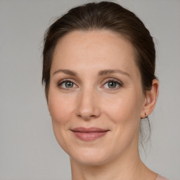 Joyful white adult female with medium  brown hair and grey eyes